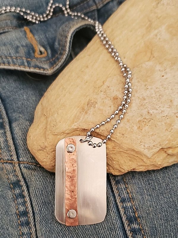mixed metal dog tag necklace on stone & denim